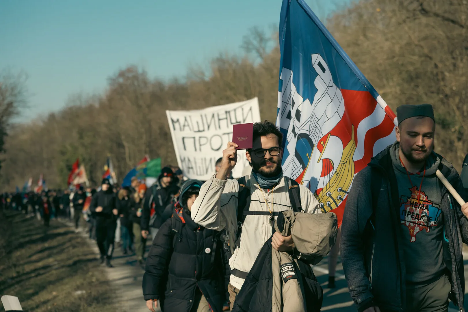 A long line of students, a student with his booklet and his colleague carrying the flag of Belgrade are in the centre of the frame.